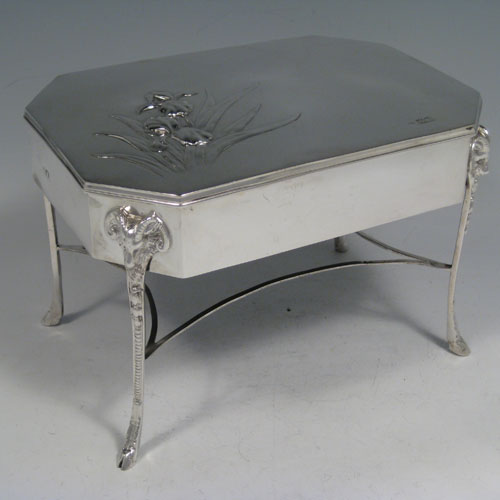 Antique Edwardian sterling silver jewelery box with hand-chased orchid decoration, sitting on four rams head feet, and having a gold-gilt and maroon velvet-lined interior. Made by William Comyns of London in 1904. Height 13 cms (5 inches), length 19 cms (7.5 inches), width 14 cms (5.5 inches).