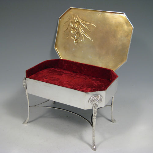 Antique Edwardian sterling silver jewelery box with hand-chased orchid decoration, sitting on four rams head feet, and having a gold-gilt and maroon velvet-lined interior. Made by William Comyns of London in 1904. Height 13 cms (5 inches), length 19 cms (7.5 inches), width 14 cms (5.5 inches).