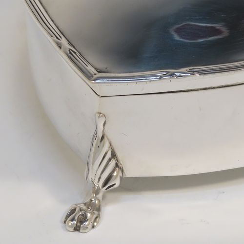 A pretty Antique Edwardian Sterling Silver jewellery box, having a plain heart-shaped body with straight sides, a hinged lid with an applied ribbon and reed border, and dark-blue velvet-lined interior, and all sitting on three cast lions-paw feet. This beautiful heart-shaped silver jewelery box was made by T. H. Hazlewood of Birmingham in 1907. The dimensions of this fine hand-made antique silver jewelery box are length 10 cms (4 inches), width 11 cms (4.3 inches), and height 4 cms (1.5 inches).  