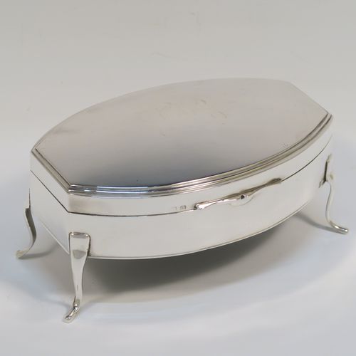 A very elegant Antique Sterling Silver jewelery box, having a plain oval-shaped body with straight sides and squared-off ends, a slightly domed hinged lid with a reeded border, a gold gilt and cream velvet-lined interior, and all sitting on four plain feet. This handsome silver jewellery box was made by Edward Souter Barnsley of Birmingham in 1919. The dimensions of this fine hand-made antique silver jewellery box are width 13cms (5 inches), depth 9cms (3.5 inches), and height 6 cms (2.3 inches)   