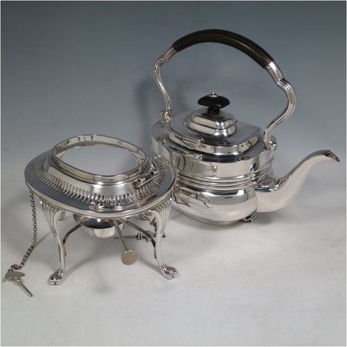 An Antique Edwardian Sterling Silver tea kettle on a burner stand, having a Georgian style rectangular baluster body, with a hinged domed lid, an insulated wooden handle and finial, and sitting on an original burner stand with a pierced border and four fluted feet. Made by Mappin & Webb of Sheffield in 1903. The dimensions of this fine hand-made antique silver kettle are length 23 cms (9 inches), height 33 cms (13 inches), width 15 cms (6 inches), and the total weight is approx. 1,145g (37 troy ounces).   