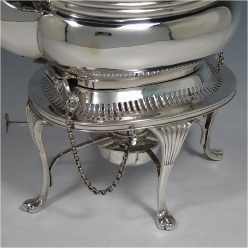 An Antique Edwardian Sterling Silver tea kettle on a burner stand, having a Georgian style rectangular baluster body, with a hinged domed lid, an insulated wooden handle and finial, and sitting on an original burner stand with a pierced border and four fluted feet. Made by Mappin & Webb of Sheffield in 1903. The dimensions of this fine hand-made antique silver kettle are length 23 cms (9 inches), height 33 cms (13 inches), width 15 cms (6 inches), and the total weight is approx. 1,145g (37 troy ounces).   