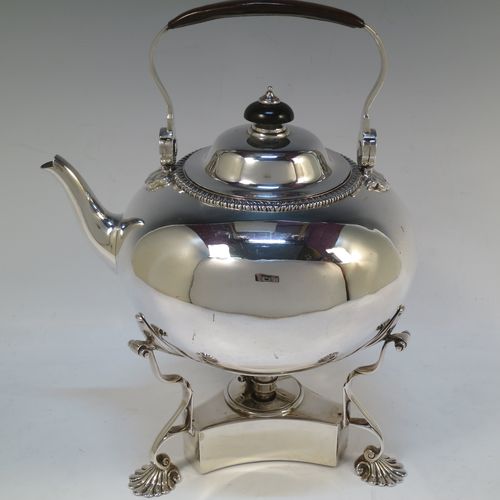 A very handsome Antique Victorian Sterling Silver tea kettle on a burner stand, having a plain round bellied body with an applied gadroon border, a lift-off lid with wooden finial, a leather covered hinged handle, and sitting on an original burner stand with removable central wick and three cast shell feet. Made by Joshua Vander of London in 1893. The dimensions of this fine hand-made antique silver kettle are length 21 cms (8.25 inches), height 27.5 cms (10.75 inches), width 18 cms (7 inches), and the total weight is approx. 770g (24.8 troy ounces).   