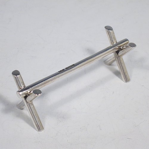 A Sterling Silver Art Deco pair of knife rests, with very plain geometric rest ends, and plain central struts. Made by Mappin & Webb of Sheffield in 1926. The dimensions of this fine hand-made pair of silver knife rests are length 9 cms (3.5 inches), height 3 cms (1.3 inches), and they weigh a total of approx. 128g (4 troy ounces).    