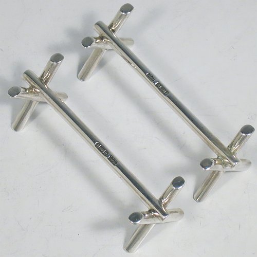 A Sterling Silver Art Deco pair of knife rests, with very plain geometric rest ends, and plain central struts. Made by Mappin & Webb of Sheffield in 1926. The dimensions of this fine hand-made pair of silver knife rests are length 9 cms (3.5 inches), height 3 cms (1.3 inches), and they weigh a total of approx. 128g (4 troy ounces).    