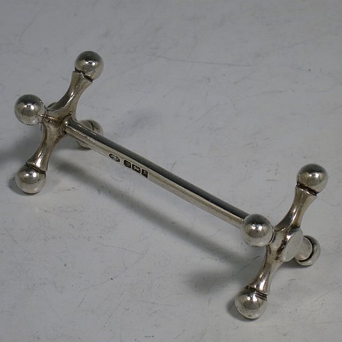 An Antique Edwardian Sterling Silver pair of knife rests, with traditional cast Jack-style rest ends, and plain round central struts. Made by William Hutton & Sons of Sheffield in 1910. The dimensions of this fine hand-made pair of antique silver knife rests are length 8 cms (3 inches), height 3 cms (1.25 inches), and they weigh a total of approx. 101g (3.3 troy ounces).    