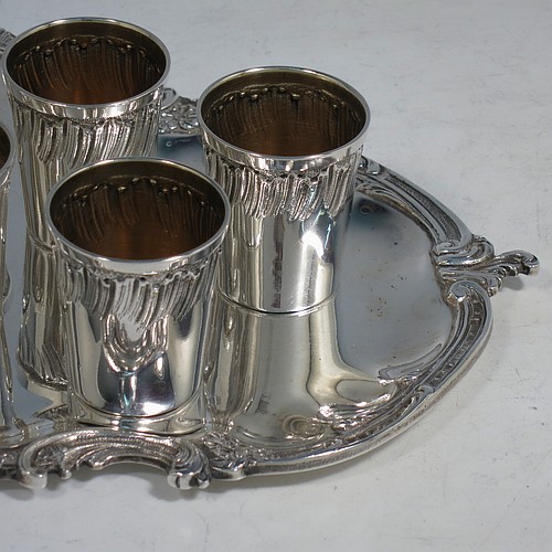 An Antique Victorian French First Quality Standard (950 std) sterling silver set of six liqueor tots / measures and original serving salver, the tots having round straight-sided bodies with gold-gilt interiors and hand-chased swirl-fluted upper borders, the salver with a plain ground and an applied cast foliate border. Made in France in ca. 1890. The dimensions of this fine hand-made antique silver liqueur set are height of tots 4 cms (1.5 inches), length of serving tray 20 cms (8 inches), and the total weight is approx. 285g (9.2 troy ounces).   