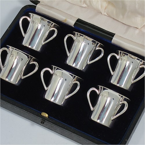 An Antique Edwardian Sterling Silver set of six liqueor tots or measures, round straight-sided bodies with three loop side-handles, all in their original cream satin and dark blue velvet-lined presentation box. Made by Elkington and Co., of Birmingham in 1909. The dimensions of this fine hand-made antique silver liqueur set are height 4 cms (1.5 inches), diameter 4 cms (1.5 inches), and the total weight is approx. 195g (6.3 troy ounces).    