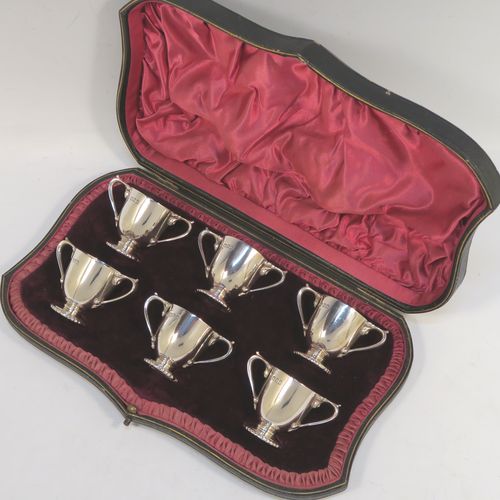 A very handsome Antique Edwardian Sterling Silver set of six liqueur tots or measures, having round trophy style bodies, with two loop side-handles, and sitting on pedestal feet, all in their original maroon satin and velvet-lined presentation box. This beautiful antique set of silver tots were made by Whakeley and Wheeler of London in 1904. The dimensions of this fine hand-made antique silver liqueur set are height 4 cms (1.5 inches), diameter 3.5 cms (1.3 inches), and the total weight is approx. 223g (7.2 troy ounces).  