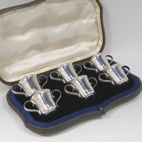 A handsome Antique Edwardian Sterling Silver set of six liqueor tots or measures in a porringer style, having plain round bodies with tapering sides, two reeded side-handles, and sitting on flat bases, all in their original cream satin and dark blue velvet presentation box. This elegant set of liqueur measures were made by Wakely and Wheeler of London in 1903. The dimensions of this fine hand-made antique silver liqueur tot set are height 4 cms (1.5 inches), diameter at lip 4 cms (1.5 inches), and their total weight is approx. 189g (6 troy ounces).   