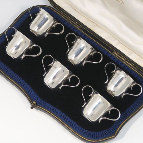 A handsome Antique Edwardian Sterling Silver set of six liqueor tots or measures in a porringer style, having plain round bodies with tapering sides, two reeded side-handles, and sitting on flat bases, all in their original cream satin and dark blue velvet presentation box. This elegant set of liqueur measures were made by Wakely and Wheeler of London in 1903. The dimensions of this fine hand-made antique silver liqueur tot set are height 4 cms (1.5 inches), diameter at lip 4 cms (1.5 inches), and their total weight is approx. 189g (6 troy ounces).   