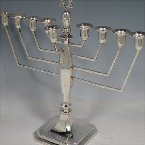 A Sterling Silver Hanukkah Menorah in an Art Deco style, having an octagonal panelled body sitting on a pedestal foot, with a removable Shamus candle holder. Made in Birmingham in 1948. The dimensions of this fine hand-made silver menorah are height 23 cms (9 inches), spread across arms 25 cms (9.75 inches), and it weighs approx. 248g (8 troy ounces) Please note that this item is not filled so the whole weight is silver.    