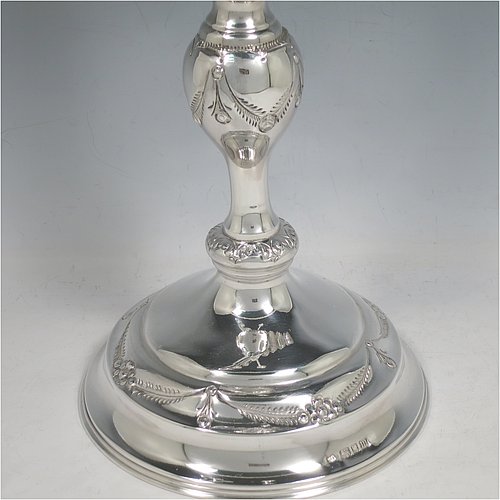 A rare and large Sterling Silver Hanukkah Menorah in a traditional style, having a round baluster body with hand-chased garlands of flowers, removable nozzles for cleaning, with bands of applied beading, and all sitting on a pedestal foot. Made by Morris Salkind of Birmingham in 1927. The dimensions of this fine hand-made silver menorah are height 49 cms (19.25 inches), spread across arms 33 cms (13 inches), and it weighs approx. 992g (32 troy ounces) Please note that this item is NOT filled so the whole weight is silver.    