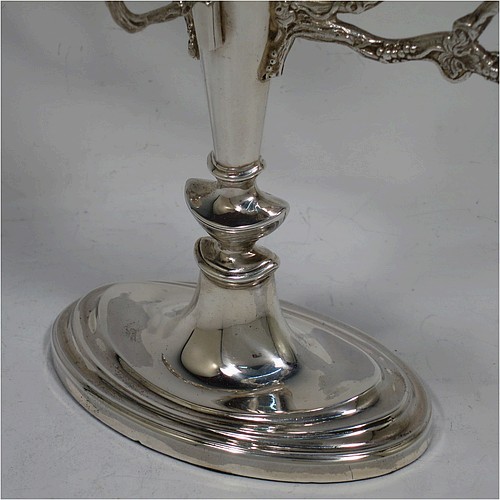 A pretty Sterling Silver Hanukkah Menorah, having a neoclassical style plain oval urn-shaped main body sitting on a pedestal foot, with cast grapevine style arms, and a removable Shamus candle holder. Made by D. J. Silver of London in 1970. The dimensions of this fine hand-made silver menorah are height 21 cms (8.25 inches), and spread across arms 26 cms (10.25 inches).   