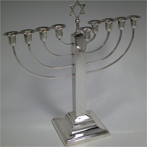 A Sterling Silver Hanukkah Menorah in an Art Deco style, having a plain panelled column, sitting on a stepped base. Made by Britton, Gould and Co., of Birmingham in 1936. The dimensions of this fine hand-made Art Deco silver menorah are height 25.5 cms (10 inches), spread across arms 24 cms (9.5 inches), and it weighs approx. 310g (10 troy ounces). Please note that this item is NOT filled so the whole weight is silver.   