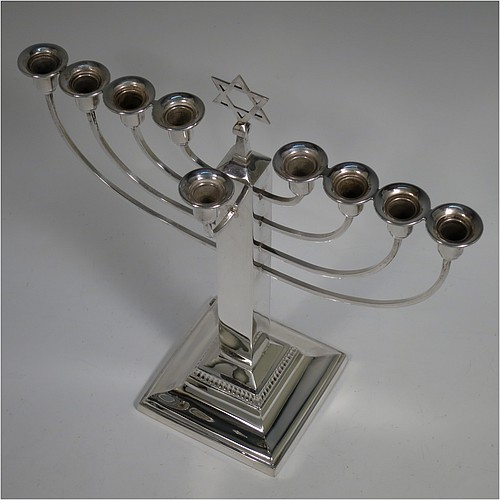 A Sterling Silver Hanukkah Menorah in an Art Deco style, having a plain panelled column, sitting on a stepped base. Made by Britton, Gould and Co., of Birmingham in 1936. The dimensions of this fine hand-made Art Deco silver menorah are height 25.5 cms (10 inches), spread across arms 24 cms (9.5 inches), and it weighs approx. 310g (10 troy ounces). Please note that this item is NOT filled so the whole weight is silver.   