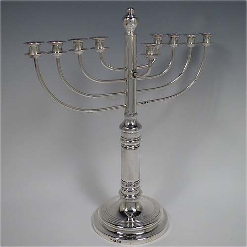 A Sterling Silver Hanukkah Menorah in a traditional style with rounded wire-work arms, having a round baluster body with hand-chased reeded borders, and all sitting on a pedestal foot. Made by Siomund Zyto of London in 1924. The dimensions of this fine hand-made silver menorah are height 31 cms (12.25 inches), spread across arms 27 cms (10.75 inches), and it weighs approx. 460g (14.8 troy ounces). Please note that this item is NOT filled so the whole weight is silver.    