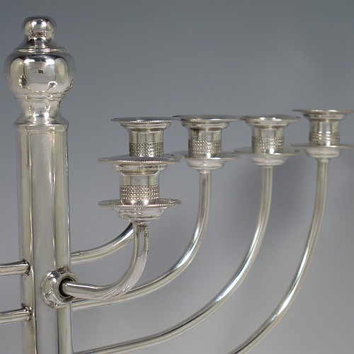 A Sterling Silver Hanukkah Menorah in a traditional style with rounded wire-work arms, having a round baluster body with hand-chased reeded borders, and all sitting on a pedestal foot. Made by Siomund Zyto of London in 1924. The dimensions of this fine hand-made silver menorah are height 31 cms (12.25 inches), spread across arms 27 cms (10.75 inches), and it weighs approx. 460g (14.8 troy ounces). Please note that this item is NOT filled so the whole weight is silver.    