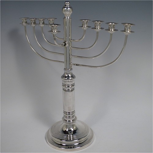 A Sterling Silver Hanukkah Menorah in a traditional style with rounded wire-work arms, having a round baluster body with hand-chased reeded borders, and all sitting on a pedestal foot. Made by Siomund Zyto of London in 1924. The dimensions of this fine hand-made silver menorah are height 31 cms (12.25 inches), spread across arms 27 cms (10.75 inches), and it weighs approx. 460g (14.8 troy ounces). Please note that this item is NOT filled so the whole weight is silver.    