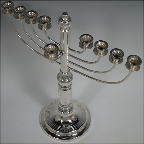 A Sterling Silver Hanukkah Menorah in a traditional style with rounded wire-work arms, having a round baluster body with hand-chased reeded borders, and all sitting on a pedestal foot. Made by Siomund Zyto of London in 1924. The dimensions of this fine hand-made silver menorah are height 31 cms (12.25 inches), spread across arms 27 cms (10.75 inches), and it weighs approx. 460g (14.8 troy ounces). Please note that this item is NOT filled so the whole weight is silver.    