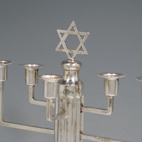 Sterling silver Menorah, having a stepped base with bead borders, and a fluted corinthian style column. Made in Birmingham in 1930. Height 28 cms (11 inches), spread across arms 28 cms (11 inches). Weight approx. 420g (13.5 troy ounces) Please note that this item is not filled. 
