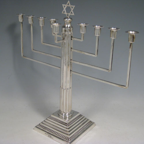 Sterling silver Menorah, having a stepped base with bead borders, and a fluted corinthian style column. Made in Birmingham in 1930. Height 28 cms (11 inches), spread across arms 28 cms (11 inches). Weight approx. 420g (13.5 troy ounces) Please note that this item is not filled. 
