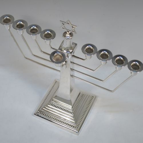 A very elegant Sterling Silver Hanukkah Menorah in an Art Deco style, having a square panelled body with bead-edged borders, a removable Shamus candle holder, and sitting on a pedestal foot. Made by Alexander Smith of Birmingham in 1977. The dimensions of this fine hand-made silver menorah are height 26 cms (10.25 inches), spread across arms 26 cms (10.25 inches), and it weighs approx. 352g (11.4 troy ounces) Please note that this item is not filled so the whole weight is silver.  