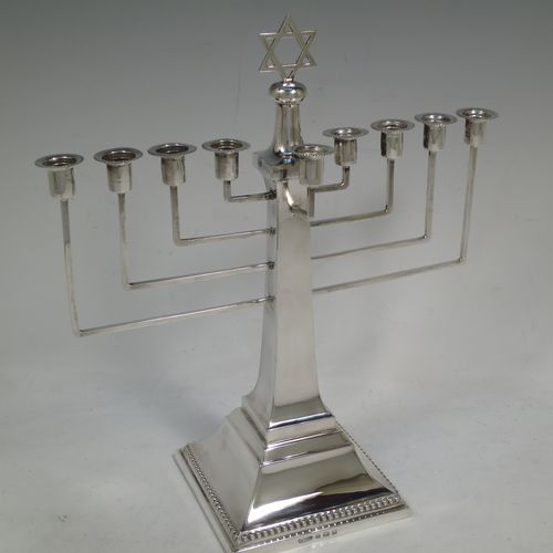 A very elegant Sterling Silver Hanukkah Menorah in an Art Deco style, having a square panelled body with bead-edged borders, and sitting on a pedestal foot. Made by Britten, Gould and Co., of Birmingham in 1931. The dimensions of this fine hand-made silver menorah are height 26.5 cms (10.5 inches), spread across arms 23.5 cms (9.25 inches), and it weighs approx. 320g (10.3 troy ounces) Please note that this item is not filled so the whole weight is silver.    