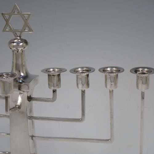 A very elegant Sterling Silver Hanukkah Menorah in an Art Deco style, having a square panelled body with bead-edged borders, and sitting on a pedestal foot. Made by Britten, Gould and Co., of Birmingham in 1931. The dimensions of this fine hand-made silver menorah are height 26.5 cms (10.5 inches), spread across arms 23.5 cms (9.25 inches), and it weighs approx. 320g (10.3 troy ounces) Please note that this item is not filled so the whole weight is silver.    