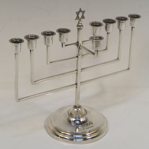 A small but very elegant Sterling Silver Hanukkah Menorah in an Art Deco style, having a plain square cross-section body with matching arms, a removable Shamus candle holder, and sitting on a plain round stepped pedestal foot. This handsome silver Menorah was made by Nathan Shore of London in 1926. The dimensions of this fine hand-made silver Hanukkah Menorah are height 18 cms (7 inches), spread across arms 19.7 cms (7.65 inches), and it weighs approx. 243g (7.8 troy ounces) Please note that this item is not filled so the whole weight is silver.   