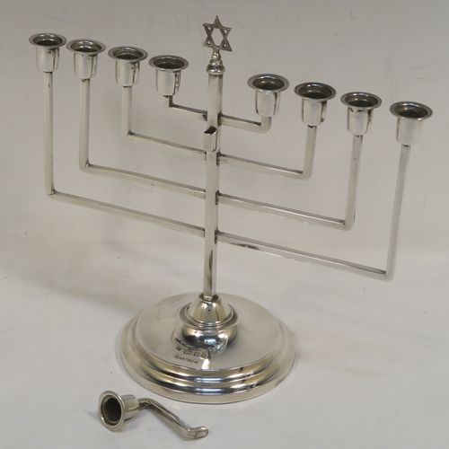 A small but very elegant Sterling Silver Hanukkah Menorah in an Art Deco style, having a plain square cross-section body with matching arms, a removable Shamus candle holder, and sitting on a plain round stepped pedestal foot. This handsome silver Menorah was made by Nathan Shore of London in 1926. The dimensions of this fine hand-made silver Hanukkah Menorah are height 18 cms (7 inches), spread across arms 19.7 cms (7.65 inches), and it weighs approx. 243g (7.8 troy ounces) Please note that this item is not filled so the whole weight is silver.   