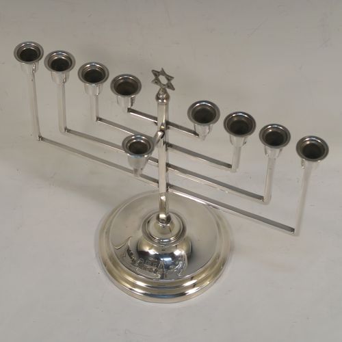 A small but very elegant Sterling Silver Hanukkah Menorah in an Art Deco style, having a plain square cross-section body with matching arms, a removable Shamus candle holder, and sitting on a plain round stepped pedestal foot. This handsome silver Menorah was made by Nathan Shore of London in 1926. The dimensions of this fine hand-made silver Hanukkah Menorah are height 18 cms (7 inches), spread across arms 19.7 cms (7.65 inches), and it weighs approx. 243g (7.8 troy ounces) Please note that this item is not filled so the whole weight is silver.   