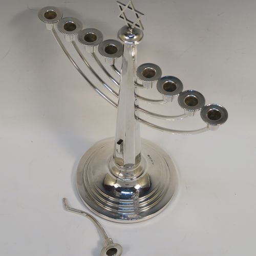 A very elegant Sterling Silver Hanukkah Menorah in a traditional style with rounded wire-work arms, having an octagonal panelled body with tapering sides, an original removable Shamus candle holder, and all sitting on a round stepped pedestal foot. This handsome silver menorah was made in Birmingham in 1957. The dimensions of this fine hand-made silver menorah are height 26 cms (10.25 inches), and spread across arms 21 cms (8.25 inches).   