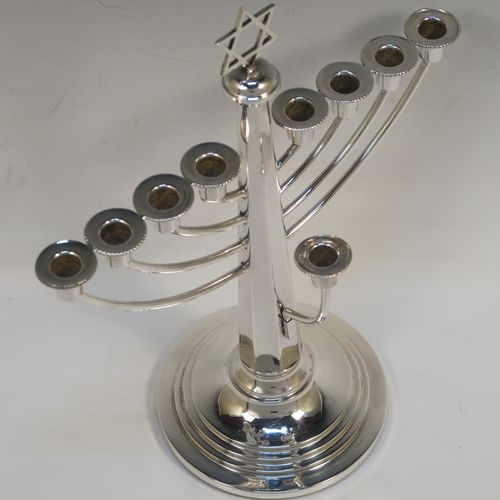 A very elegant Sterling Silver Hanukkah Menorah in a traditional style with rounded wire-work arms, having an octagonal panelled body with tapering sides, an original removable Shamus candle holder, and all sitting on a round stepped pedestal foot. This handsome silver menorah was made in Birmingham in 1957. The dimensions of this fine hand-made silver menorah are height 26 cms (10.25 inches), and spread across arms 21 cms (8.25 inches).   