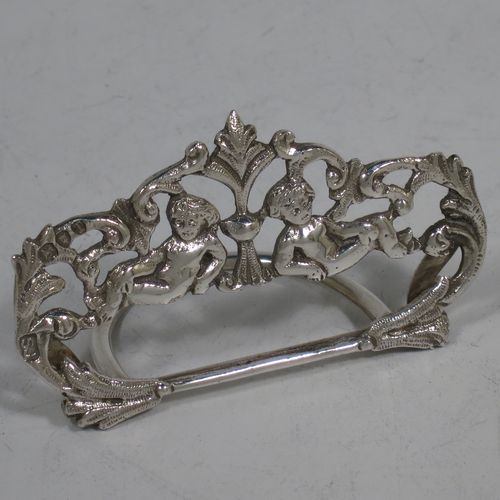 A very pretty Antique Victorian Sterling Silver set of four place card holders, having cast bodies with reclining cherubs over scroll and floral decoration, and sitting on half-circle wire-work bases. Made by Samuel Jacob of London in 1894. The dimensions of this fine set of antique silver place card holders are width 7 cms (2.75 inches), height 4 cms (1.5 inches), depth 3 cms (1.25 inches), and they weigh a total of approx. 106g (3.4 troy ounces).   