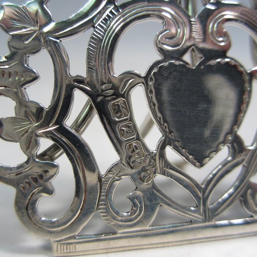 Antique Victorian sterling silver set of four menu or place card holders, having hand-pierced work with scrolls, three-leaf clovers, and heart-shaped cartouches. Please note that two are made in Birmingham in 1899, and two are marked sterling made in ca. 1890. Height 5 cms (2 inches), width 5 cms (2 inches). Total weight approx. 78g (2.5 troy ounces).