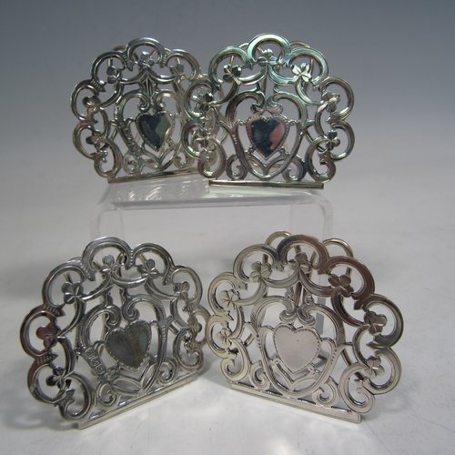 Antique Victorian sterling silver set of four menu or place card holders, having hand-pierced work with scrolls, three-leaf clovers, and heart-shaped cartouches. Please note that two are made in Birmingham in 1899, and two are marked sterling made in ca. 1890. Height 5 cms (2 inches), width 5 cms (2 inches). Total weight approx. 78g (2.5 troy ounces).