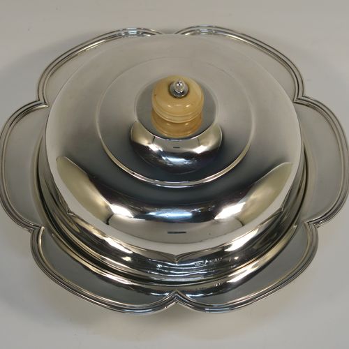 An elegant Sterling Silver muffin dish, having a round body with an applied and shaped reeded petal border, a domed lift-off lid with a bone finial, an original internal liner, and all sitting on a flat base. This beautiful silver caviar or muffin dish was made by Mappin and Webb of Sheffield in 1926. The dimensions of this fine hand-made silver muffin or caviar dish are diameter 18 cms (7 inches), height 10 cms (4 inches), and it weighs approx. 550g (17.7 troy ounces).

   