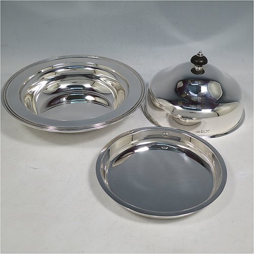 An Antique Sterling Silver muffin dish, having a plain round body with reeded border, a domed lift-off lid with wooden finial, an interior lift-out liner with space underneath for hot water or crushed ice, and sitting on a flat base. Made by Harrison Brothers & Howson of in 1912. The dimensions of this fine hand-made antique silver muffin dish are diameter 18.5 cms (7.3 inches), height 11.5 cms (4.5 inches), and it weighs approx. 486g (15.7 troy ounces).   