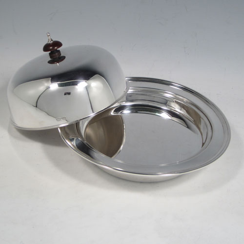 Sterling silver muffin dish, having a plain round body, with lift-off lid and wooden finial, an interior lift-out liner, and sitting on a flat base. Made by the Adie Brothers of Birmingham in 1939. The dimensions of this fine hand-made silver muffin dish are diameter 18 cms (7 inches), height 10 cms (4 inches), and it weighs approx. 480g (15.5 troy ounces).