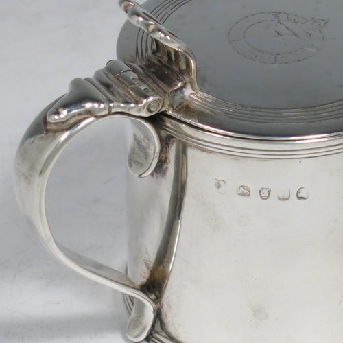 An Antique Georgian Sterling Silver drum mustard pot, having a plain cylindrical body, with applied reeded borders, a hinged lid with pierced thumb-piece, a plain scroll handle, and an internal blue glass liner. Made by Rebecca Emes & Edward Barnard I of London in 1818. The dimensions of this fine hand-made antique silver mustard pot are height 8 cms (3 inches), diameter 6 cms (2.3 inches), and it weighs approx. 144g (4.6 troy ounces). Please note that this item has an engraved crest on the top of the lid.  