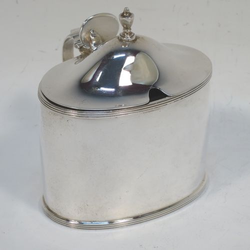 A very handsome and large Scottish Sterling Silver mustard pot, having a plain oval body with slightly curved sides, with applied reeded borders, a domed lid with an urn-shaped finial, a scroll side-handle with plain oval thumb-piece, and a fitted blue glass liner. Made by Robert Sawers Ltd of Edinburgh in 1936. The dimensions of this fine hand-made Scottish silver mustard pot are height 8.5 cms (3.3 inches), length 8 cms (3 inches), depth  (inc. handle) 8 cms (3 inches), and it weighs approx. 108g (3.5 troy ounces).