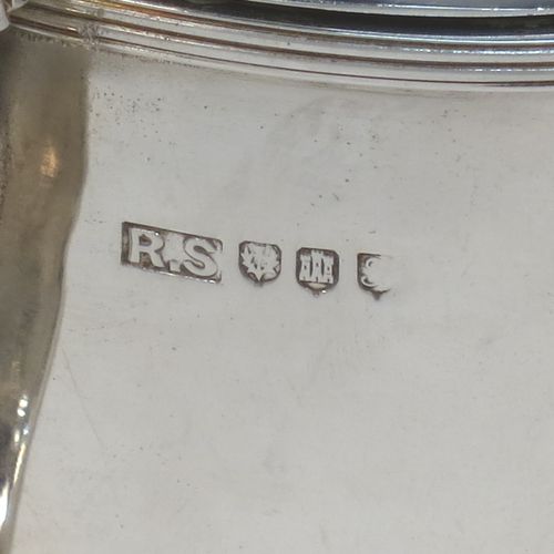 A very handsome and large Scottish Sterling Silver mustard pot, having a plain oval body with slightly curved sides, with applied reeded borders, a domed lid with an urn-shaped finial, a scroll side-handle with plain oval thumb-piece, and a fitted blue glass liner. Made by Robert Sawers Ltd of Edinburgh in 1936. The dimensions of this fine hand-made Scottish silver mustard pot are height 8.5 cms (3.3 inches), length 8 cms (3 inches), depth  (inc. handle) 8 cms (3 inches), and it weighs approx. 108g (3.5 troy ounces).