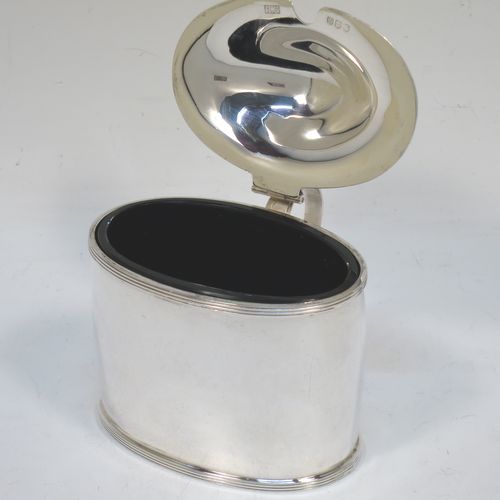 A very handsome and large Scottish Sterling Silver mustard pot, having a plain oval body with slightly curved sides, with applied reeded borders, a domed lid with an urn-shaped finial, a scroll side-handle with plain oval thumb-piece, and a fitted blue glass liner. Made by Robert Sawers Ltd of Edinburgh in 1936. The dimensions of this fine hand-made Scottish silver mustard pot are height 8.5 cms (3.3 inches), length 8 cms (3 inches), depth  (inc. handle) 8 cms (3 inches), and it weighs approx. 108g (3.5 troy ounces).