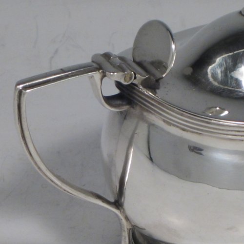 Antique Georgian sterling silver mustard pot, having a plain oval baluster body, a hinged domed lid with thumb-piece and ball finial, with applied reeded borders, a reeded scroll handle, a blue glass liner, all sitting on a flat base. Made by John Gold of London in 1801. The dimensions of this fine hand-made silver mustard pot are height 8 cms (3 inches), length 11 cms (4.25 inches), width 6 cms (2.25 inches), and it weighs approx. 115g (3.7 troy ounces).   