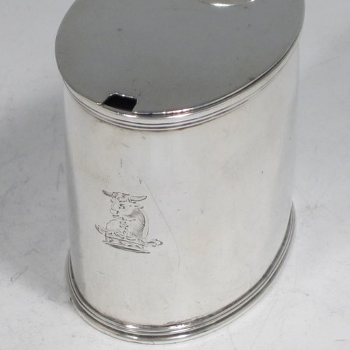 Antique Georgian sterling silver drum mustard pot, having a plain oval body with applied reeded borders, a flat hinged lid with thumb-piece, a scroll handle, and a blue-glass liner. Made by John Emes of London in 1804. The dimensions of this fine hand-made silver mustard pot are length 10 cms (4 inches), height 7.5 cms (3 inches), width 5 cms (2 inches), and it weighs approx. 137g (4.4 troy ounces). Please note that this item is crested.