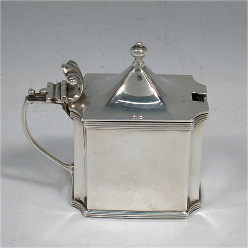 An Antique Edwardian Sterling Silver mustard pot, having a plain straight-sided body with cut-corners and applied reeded borders, a hinged domed lid with cast scroll thumb-piece and urn finial, a plain scroll handle, an original blue-glass liner, and sitting on a flat base. Made by Zachariah Barraclough & Sons of Chester in 1907. The dimensions of this fine hand-made antique silver mustard pot are length 9 cms (3.5 inches), height 9 cms (3.5 inches), and it weighs approx. 136g (4.4 troy ounces).    