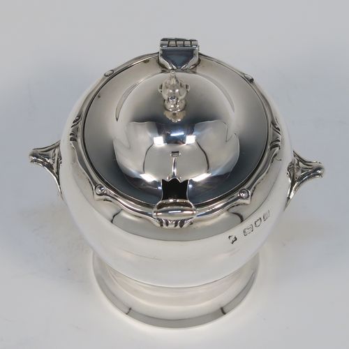 An unusual and rare Antique Edwardian Art Nouveau mustard pot, having a plain round bellied body with two cast scroll side-handles, an applied scroll style top border, a hinged lid with a cast urn finial, an internal blue glass liner, and all sitting on a flat base. This beautiful silver mustard pot comes with a garden shovel style silver spoon. This elegant silver Art Nouveau mustard pot was made by Jackson and Fullerton of London in 1909. The dimensions of this fine hand-made antique silver mustard pot are height 10 cms (4 inches), diameter 7 cms (2.75 inches), and it weighs approx. 114g (3.7 troy ounces).  