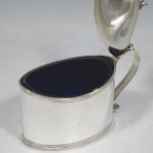 An Antique Georgian Sterling Silver mustard pot, having a plain oval straight-sided body, with applied reeded borders, a hinged domed lid with cast thumb-pieced and finial, a reeded scroll handle, a blue-glass liner, and sitting on a flat base. Made by Frances Purton & Thomas Johnson of London in 1794. The dimensions of this fine hand-made antique silver mustard pot are length 11 cms (4.25 inches), height 8.5 cms (3.3 inches), and it weighs approx. 125g (4 troy ounces).