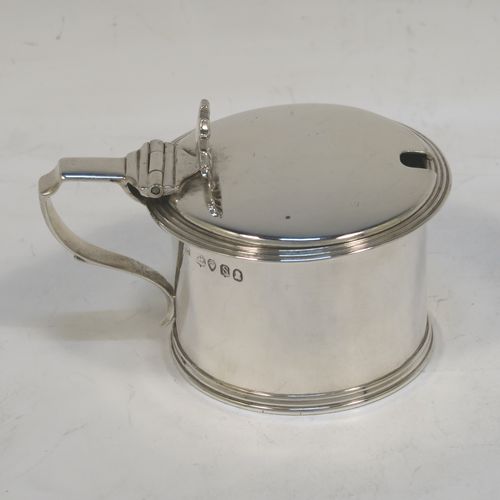 A very elegant Antique Georgian Sterling Silver drum mustard, having a plain cylindrical body, with applied reeded borders, a hinged flat lid with a cast shell thumb-piece, a scroll handle and a blue glass liner. Made by Charles Fox of London in 1833. The dimensions of this fine hand-made antique silver mustard pot are height 6 cms (2.3 inches), diameter 6.5 cms (2.5 inches), and it weighs approx. 90g (3 troy ounces).  